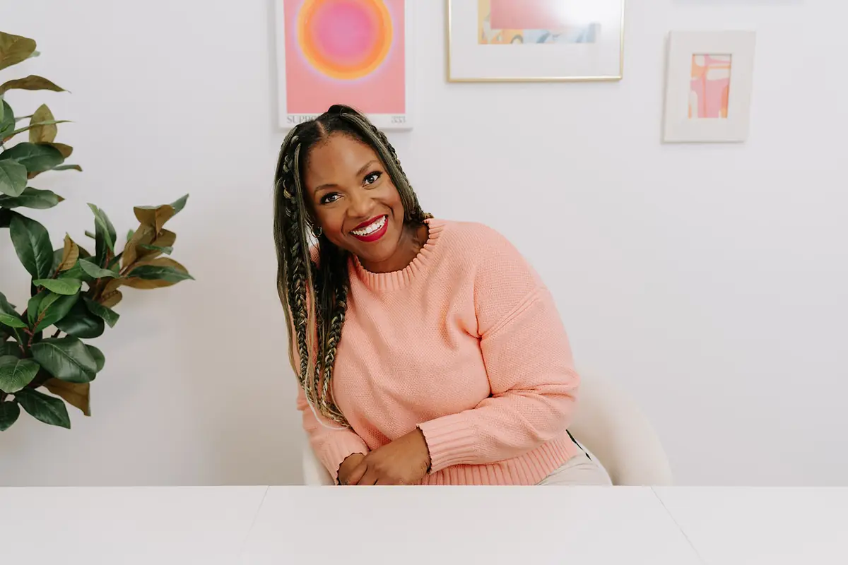 Dilys Chuinkam, Registered Psychotherapist, smiling at a desk in a bright office